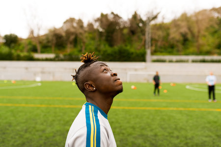 Barcelona, spain - 10 june 2020: portrait of young african black immigrant man playing soccer in team, smiling and enjoying together with teammates in pitch, football is a tool for social inclusionのeditorial素材