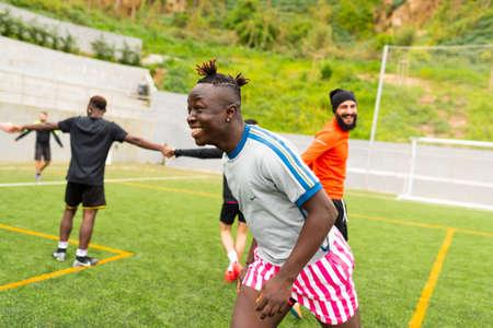 Barcelona, spain - 10 june 2020: portrait of young african black immigrant man playing soccer in team, smiling and enjoying together with teammates in pitch, football is a tool for social inclusionのeditorial素材