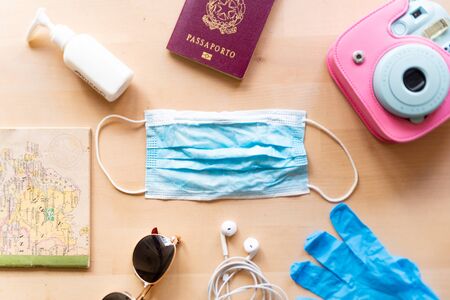 corona virus travel and tourism concept, italian passport and face mask as symbol of the traveling industry crisis and the new safety measures after the virus global outbreakの写真素材