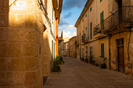 empty street in alcudia at sunset, a traditional old spanish town with historical building...
