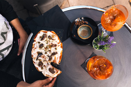 young woman eating italian bruschetta with mozzarella cheese doing italian happy hour with drink...