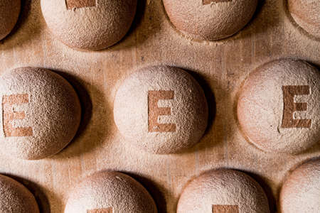 top view of fresh spelt bread dough with flour on shelf before entering the oven for baking. flat lay of fresh round bread on bakery factoryの写真素材