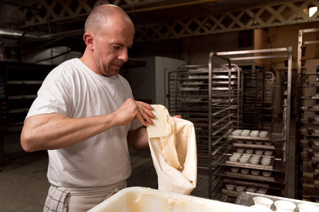 pastry chef in pastry shop filling stamps and cream. concept of traditional manual pastries...
