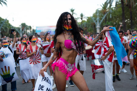 A young trans or transgender man smiling dances at 2021 Pride parade in Barcelona, Spain on...