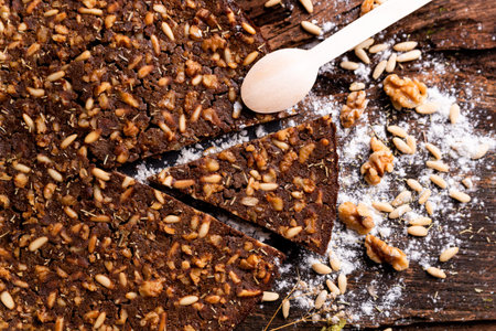 close up of traditional castagnaccio cake slice, a classic italian gluten free autumn cake on wooden...