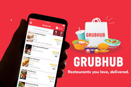 In this photo illustration the logo of the food delivery service Grubhub is seen on the screen of...