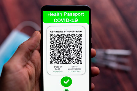 A Covid passport, also called Green Pass is seen on the screen of a mobile phone hold by a hand,...