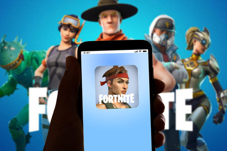 In this photo illustration the logo of the online game Fortnite  is seen on the screen of mobile...