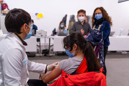 A young girl receives the first shot of Covid-19 vaccine by a nurse at a vaccination center in...