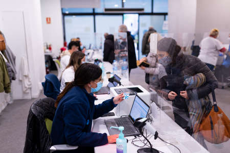A woman talks with a nurse while being received at a vaccination center in Barcelona, Spain on December 22, 2021. Following the spread of the Omicron variant, the spanish governmentのeditorial素材