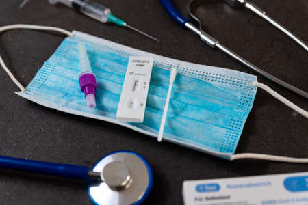 A rapid antigen test for SARS-CoV-2 or Covid is seen on a table with nasal swab stick during a rapid surge in demand due to the Omicron variant of Covid19のeditorial素材