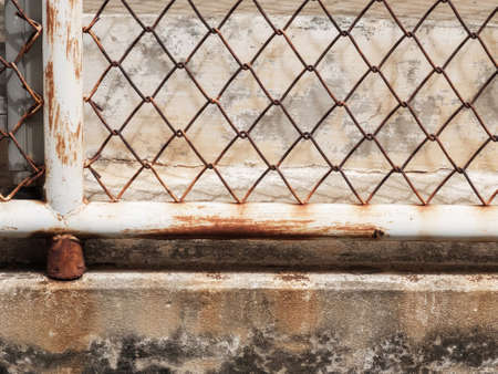 Rusty iron grid grate fence on concrete barの写真素材