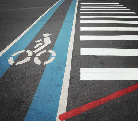 Bike lane in blue with biker symbol along with pedestrian crosswalkの写真素材