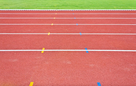 red running track lines and green field