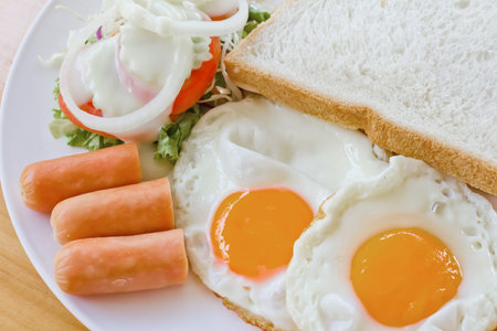 fried egg and fried sausage in a dish, american breakfast