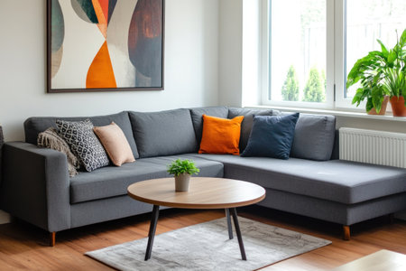 A photo of a large gray corner sofa in the center, white walls with an abstract painting on the wall above it, a modern coffee table, and a potted plant near the window, all on a wooden floor. --ar 3:2 --v 6.1 Job ID: ed5b54e5-8639-4803-9f5a-f4c307254ae4の素材