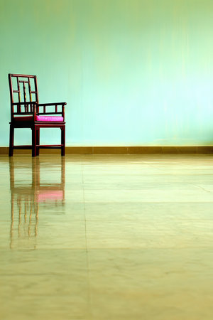 Single wooden chair with a pink cushion is positioned in the center of a room against a pastel mint green wall. The floor is a light beige tone and reflects the image of the chair. The overall feeling is one of serenity and simplicity.の素材