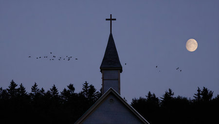 Pale-gray church steeple rises against a twilight sky, with a full moon and a flock of birds in flight, silhouetted against the pale blue-gray sky. A line of trees sits at the bottom of the image.の素材