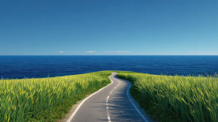 Narrow, paved road snakes gently along the crest of a grassy cliff or hill, bordered on both sides by intensely bright, tall green foliage, ultimately terminating at a vast, deep blue ocean meeting a clear, lighter blue sky at the distant horizon.の素材