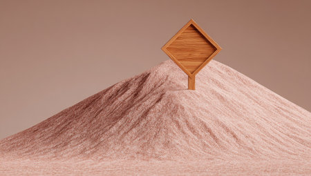 A wooden diamond shaped sign is perched on a sandy mound.の素材