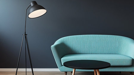 Modern living room furnished with a teal sofa, a black tripod floor lamp, and a round black coffee table against a dark gray wall. The image showcases a clean, minimalist design aesthetic.の素材