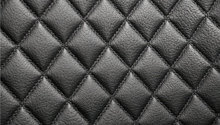 Close-up image of black quilted leather, showcasing the diamond-shaped quilting pattern and fine stitching. The texture is smooth and the color is a deep black.  The image focuses on the detailed craftsmanship of the material.の素材