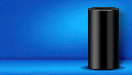 Black cylinder is positioned against a vivid blue backdrop in a  setting.  The cylinder is smooth and reflective and creates a strong visual contrast.  The backdrop is a gradient blue, adding depth to the image.の素材