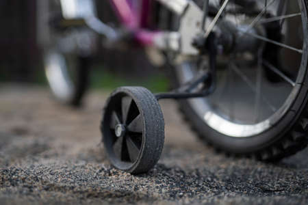 Children's bicycle with extra wheels, close-up.の写真素材