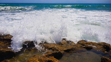 Wave of white foam crashing against the rocks