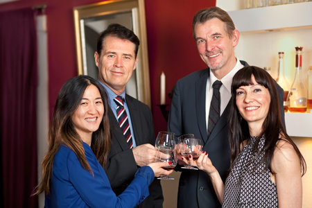 Group of multiethnic business people at a party toasting with a drink.
