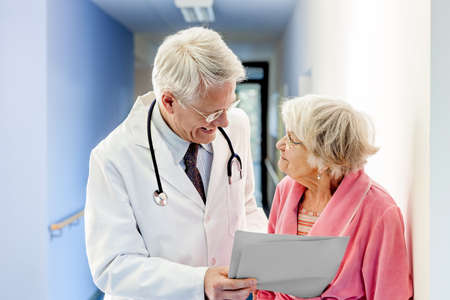 Doctor Talking to Old Woman about Good Results at the hospital.の写真素材
