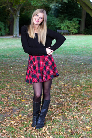 Beautiful girl enjoying a nice autumn day in a park. Posing for the photographer.の写真素材