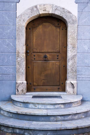 Architectural Exterior Detail of Closed Arched Wooden Door of Building Constructed from Blue Stone Marble with Stepsの写真素材