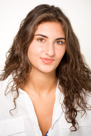Portrait of beautiful smiling young brunette woman against white background.の写真素材