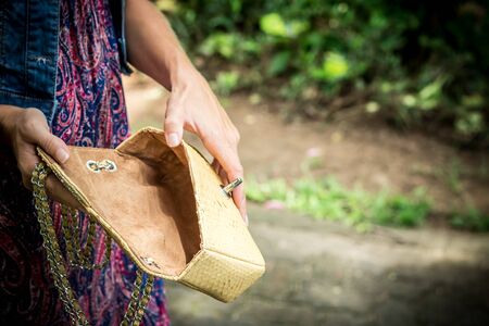 Portrait of a Beautiful fashionable caucasian brunette woman with sunglasses and luxury snakeskin python handbag posing in the park of Nusa Dua, Bali, Indonesia. Asia. Sunny day, green background.の写真素材