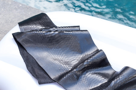 Genuine python snakeskin leather, snake skin, texture background. Swimming pool on a background.