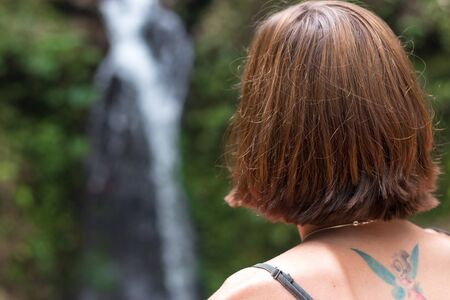 Portrait of young sexy woman in the rainforest of tropical Bali island, Indonesia. Waterfall on a background. Rare view.の写真素材