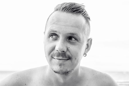 Portrait of man smiling on beach of tropical Bali island, Indonesia. Black and white photo.の写真素材
