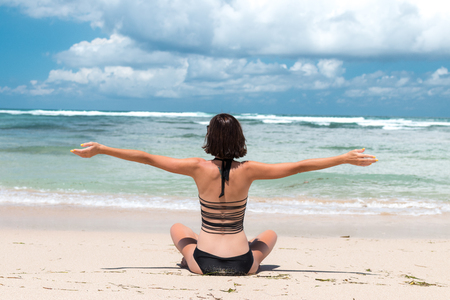 Freedom concept. Freedom and happiness woman on the tropical beach of Bali island, Indonesia. She is enjoying serene ocean nature during travel holidays vacation outdoors.の写真素材