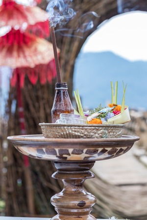 Traditional balinese offerings to gods in Bali with flowers and aromatic sticks. Tropical island Bali, Indonesia.の写真素材
