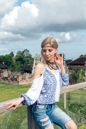 Attractive young woman in ethnic style look posing near the balinese temple, portrait. Tropical island Bali, luxury resort villa, Indonesia.の写真素材