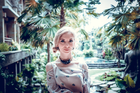 Woman is posing in a tropical garden of Bali island, Indonesia.の写真素材