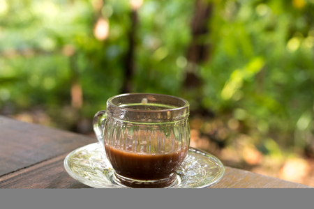 Cup of coffee over blurred plantation of coffee tree with sun lighting. Tropical Bali island, Indonesia. Authentic bali coffee.の写真素材