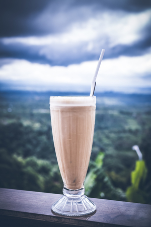 Ice coffee latte in a tall glass on a beautiful nature background. Tropical Bali island.の写真素材