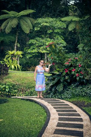 Portrait of beautiful woman posing among blooming asian flowers on Bali island, Indonesia.の写真素材