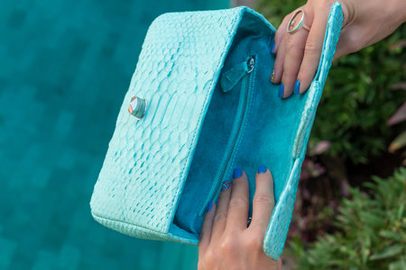 Woman holding luxury snakeskin python handbag. Bali island. Fashion bag concept on a tropical...