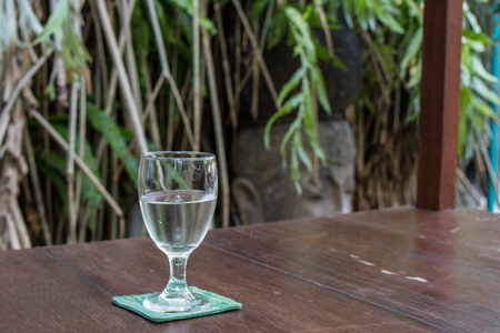 Glass of water on a wooden table in a restaurant.の写真素材