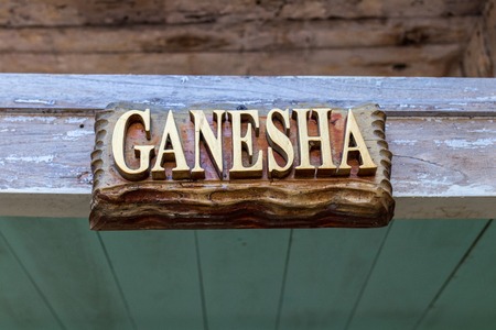 Text Ganesha on a wooden plate. Hindu God Ganesha. Ganesha Idol. Bali island.の写真素材