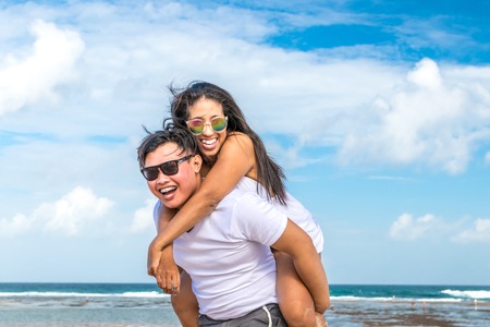 Asian couple having fun on the beach of tropical Bali island, Indonesia.の写真素材