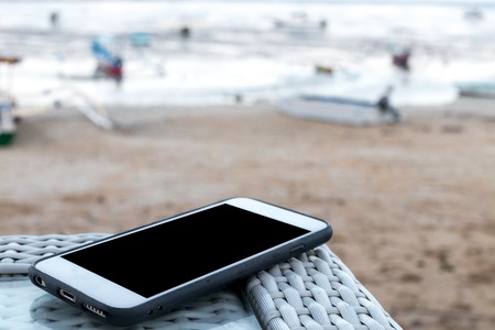smartphone with empty space on a beach background.の写真素材